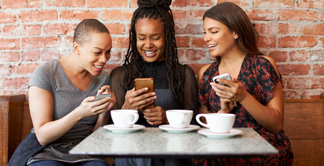 happy women looking at mobile phones